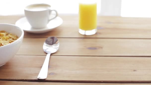 Melk gieten aan cornflakes op houten tafel — Stockvideo