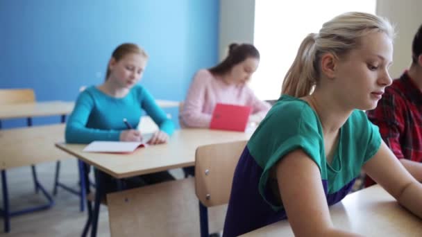 Alunos com cadernos teste de escrita na escola — Vídeo de Stock