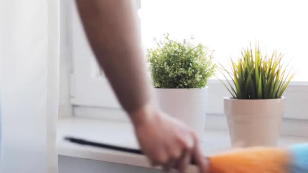 Frau mit Staubwedel putzt Fensterbank zu Hause — Stockvideo