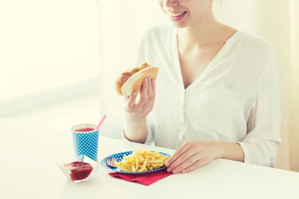 Primer plano de la mujer comiendo perrito caliente y papas fritas — Foto de Stock