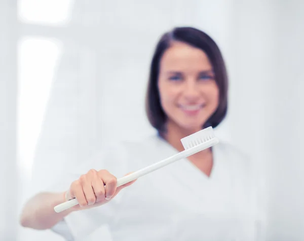 Стоматолог с зубной щеткой в больнице — стоковое фото