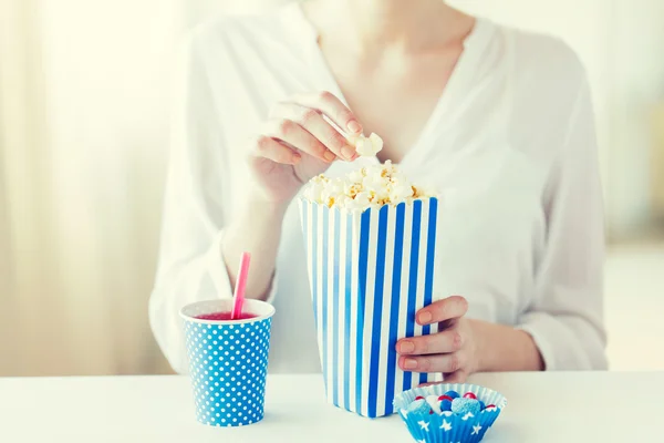 Žena jíst popcorn s nápoje a cukrovinky — Stock fotografie