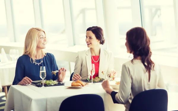 Femmes heureuses manger et parler au restaurant — Photo