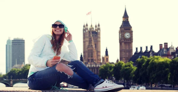 Jovem feliz com smartphone e fones de ouvido — Fotografia de Stock