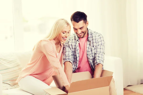 Casal feliz com caixa de pacote em casa — Fotografia de Stock