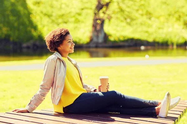 Mujer africana feliz bebe café en el parque de verano — Foto de Stock