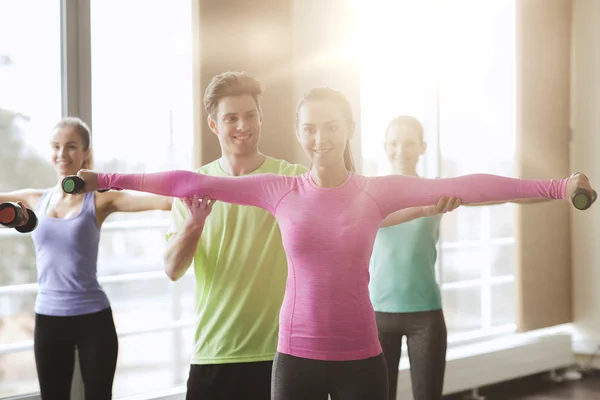 Mujeres felices y entrenador con pesas en el gimnasio — Foto de Stock