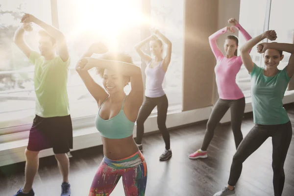 Groupe de personnes souriantes dansant en salle de gym ou studio — Photo