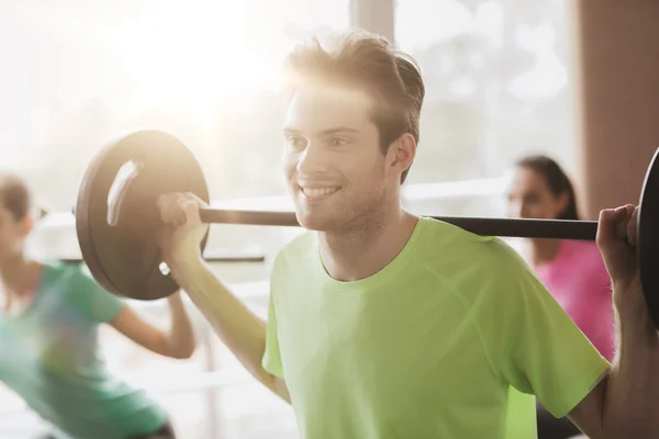 Group of people exercising with barbell in gym — Stock Photo, Image