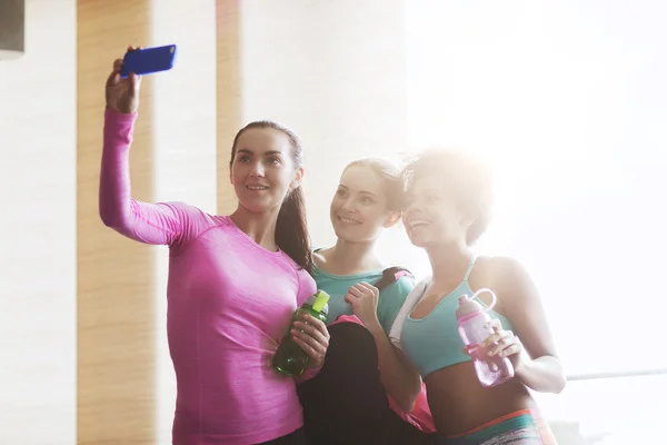 Mulheres felizes com smartphone tirando selfie no ginásio — Fotografia de Stock