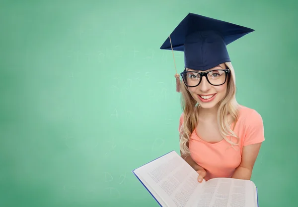 Estudiante mujer en mortero con enciclopedia — Foto de Stock