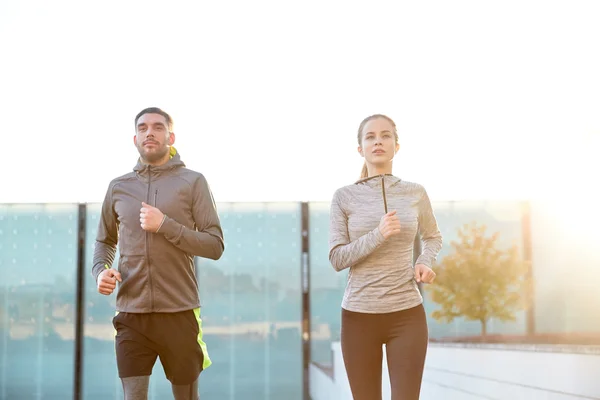 Feliz pareja corriendo arriba en la ciudad escaleras — Foto de Stock