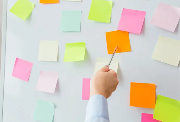 Nahaufnahme der Hand, die auf Aufkleber auf Flipchart zeigt — Stockfoto