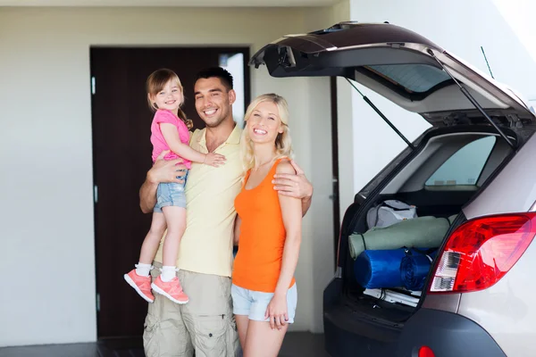 Família feliz com carro hatchback em casa estacionamento — Fotografia de Stock