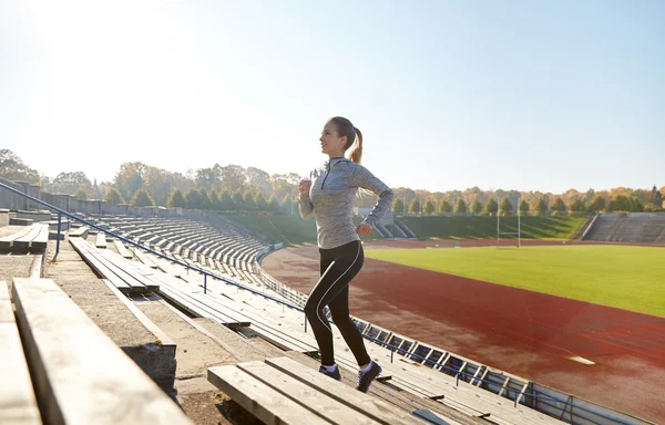 Happy young woman running upstairs on stadium — Stock Photo, Image
