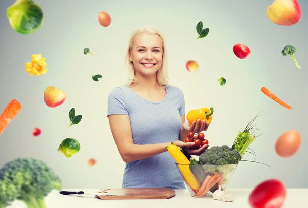 Sorrindo jovem mulher cozinhar legumes em casa — Fotografia de Stock