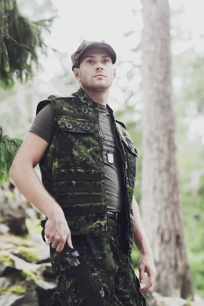 Young soldier or hunter with knife in forest — Stock Photo, Image