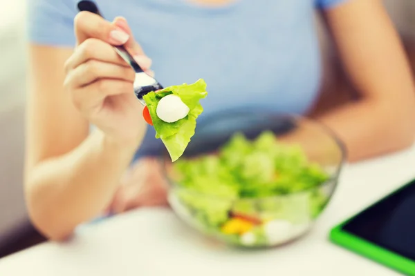 Primer plano de la mujer joven comiendo ensalada en casa — Foto de Stock