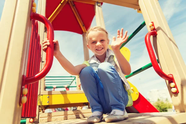 Fröhliches kleines Mädchen klettert auf Kinderspielplatz — Stockfoto