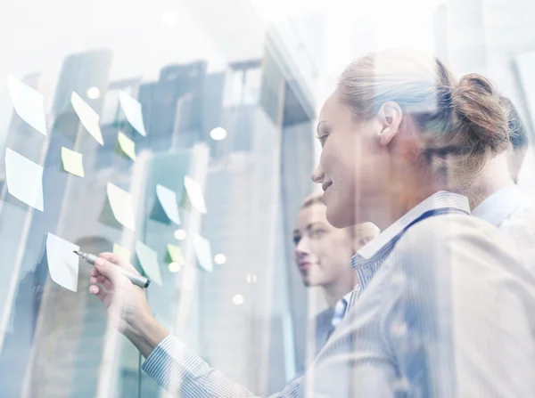 Smiling business people with marker and stickers — Stock Photo, Image