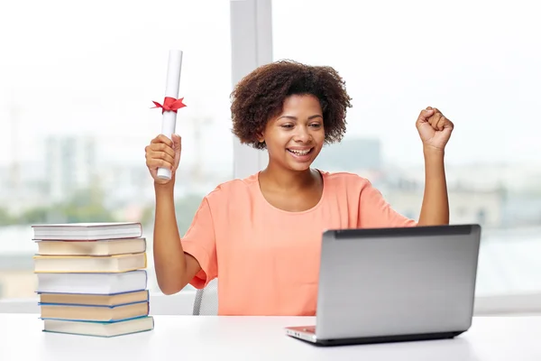 Femme africaine heureuse avec ordinateur portable, livres et diplôme — Photo