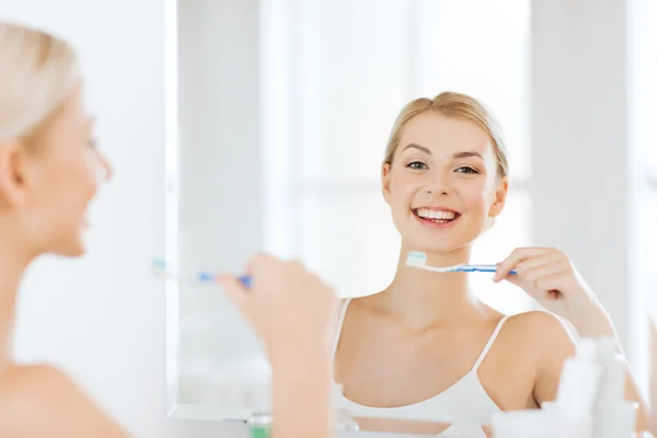Mujer con cepillo de dientes limpieza de dientes en el baño — Foto de Stock
