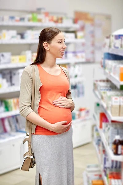 Gelukkig zwangere vrouw kiezen geneeskunde bij apotheek — Stockfoto