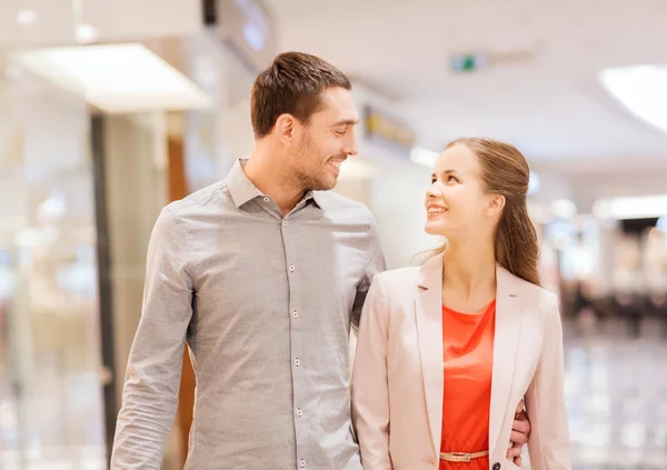 Feliz jovem casal com sacos de compras no shopping — Fotografia de Stock