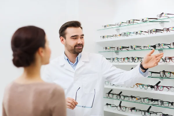 Žena a ukazující brýle v obchodě optika optik — Stock fotografie