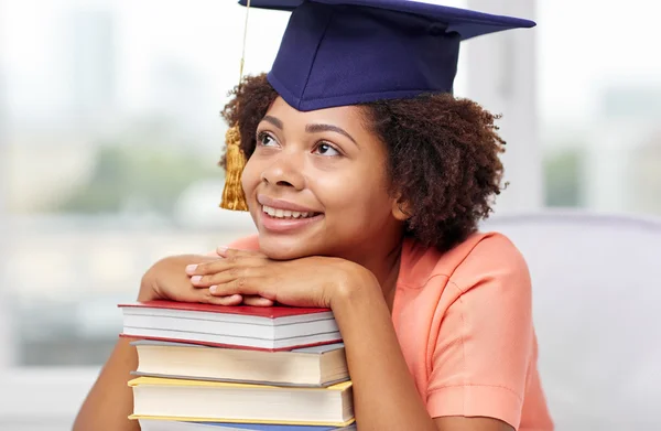 Feliz chica de soltero africano con libros en casa —  Fotos de Stock