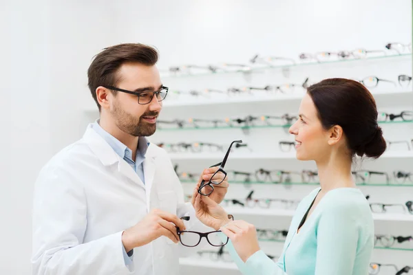 Donna e ottico che mostra gli occhiali al negozio di ottica — Foto Stock