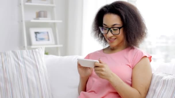 Femme africaine heureuse avec smartphone à la maison — Video