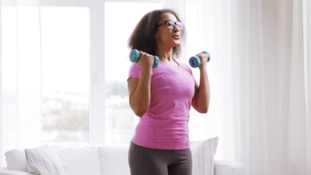 African woman exercising with dumbbells at home — Stock Video