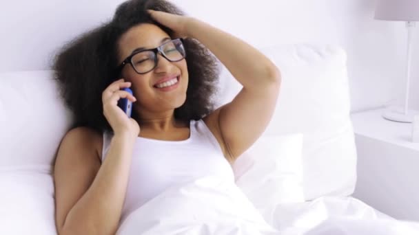 Mujer africana llamando en teléfono inteligente en la cama en casa — Vídeos de Stock