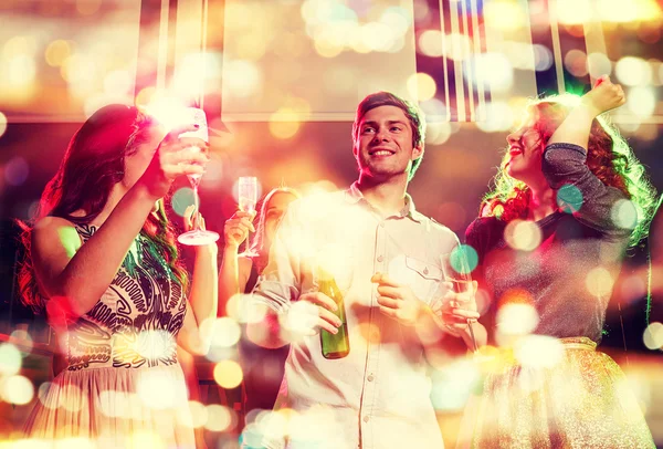 Lachende vrienden met wijn glazen en bier in club — Stockfoto