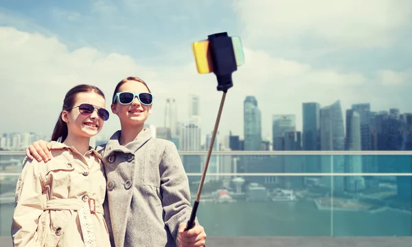 Girls with smartphone selfie stick in singapore — Stock Photo, Image