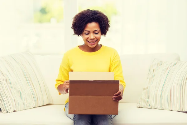 Happy african young woman with parcel box at home — Stock Photo, Image