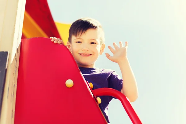 Niño pequeño y feliz escalada en el parque infantil — Foto de Stock