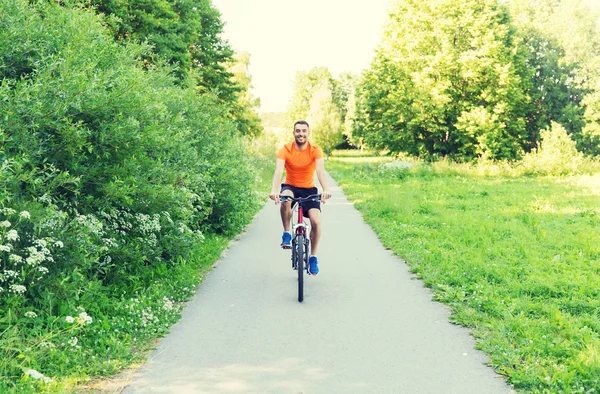 Glücklicher junger Mann, der im Freien Fahrrad fährt — Stockfoto