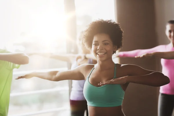 Gruppe af smilende mennesker danser i fitnesscenter eller studie - Stock-foto