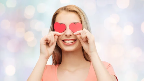 Gelukkig jonge vrouw met rood hart shapes op ogen — Stockfoto