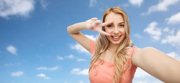 Lachende vrouw nemen selfie en tonen vredesteken — Stockfoto