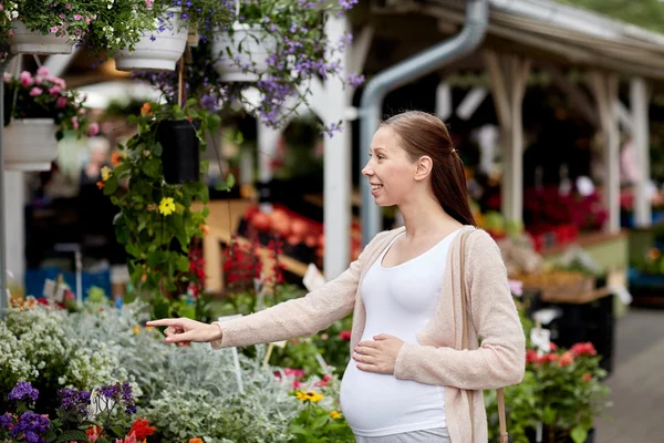 Mulher grávida escolhendo flores no mercado de rua — Fotografia de Stock