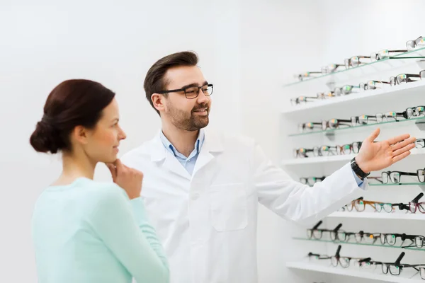 Frau und Optikerin zeigen Brille im Optikgeschäft — Stockfoto