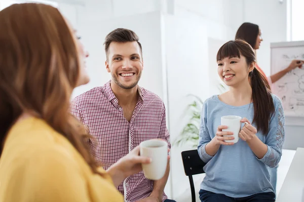 Glückliches kreatives Team trinkt Kaffee im Büro — Stockfoto