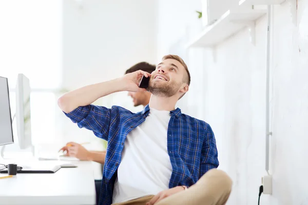 Homem criativo feliz chamando no celular no escritório — Fotografia de Stock