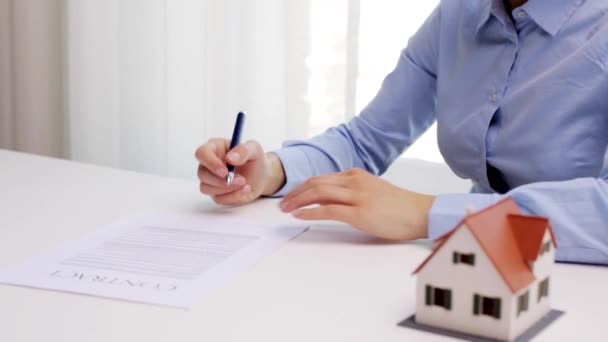 Mujer con modelo de casa y contrato de firma de pluma — Vídeo de stock