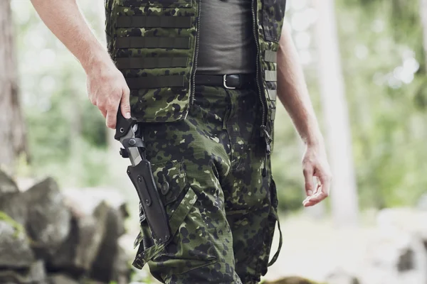 Close up of soldier or hunter with knife in forest — Stock Photo, Image