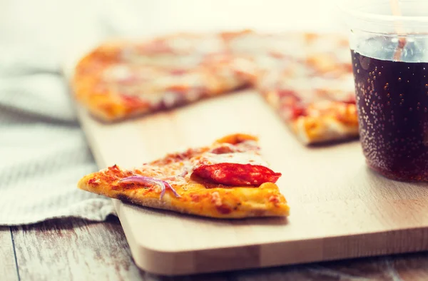 Close up of pizza with carbonated drink on table — 스톡 사진