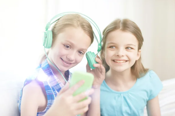 Szczęśliwy dziewcząt z smartphone i słuchawki — Zdjęcie stockowe
